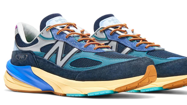 Side view of blue and orange New Balance shoes.